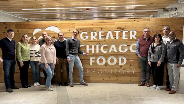 People standing in front of a sign saying Grater Chicago Food Depository
